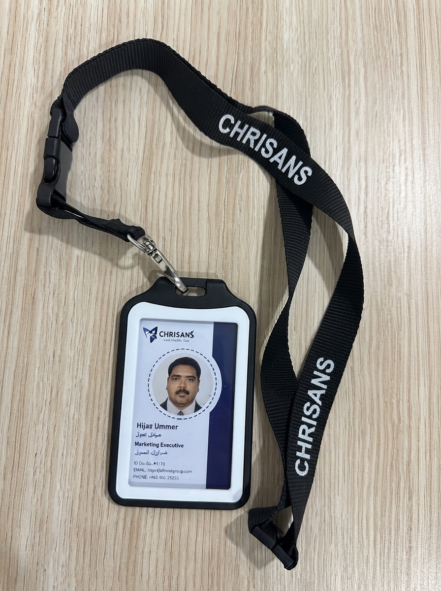 Real Chrisans Solutions PVC ID card printed in Kuwait — black lanyard and rigid holder with photo, name, role and contact details